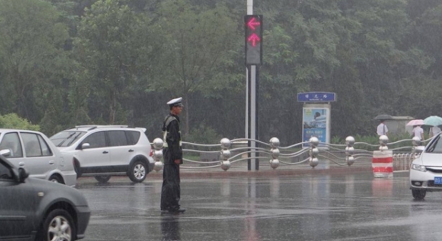 暖心！交警执勤突遇大雨 轿车车主做出这件事……