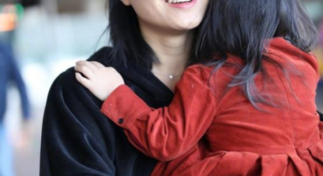 朱丹抱女儿走机场，穿“保姆装”真称职，手上钻戒大地占半个指节
