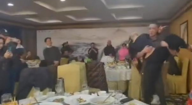 62岁杨丽萍现身饭局，被7位中年男性围绕，俩徒弟现场搂腰起舞